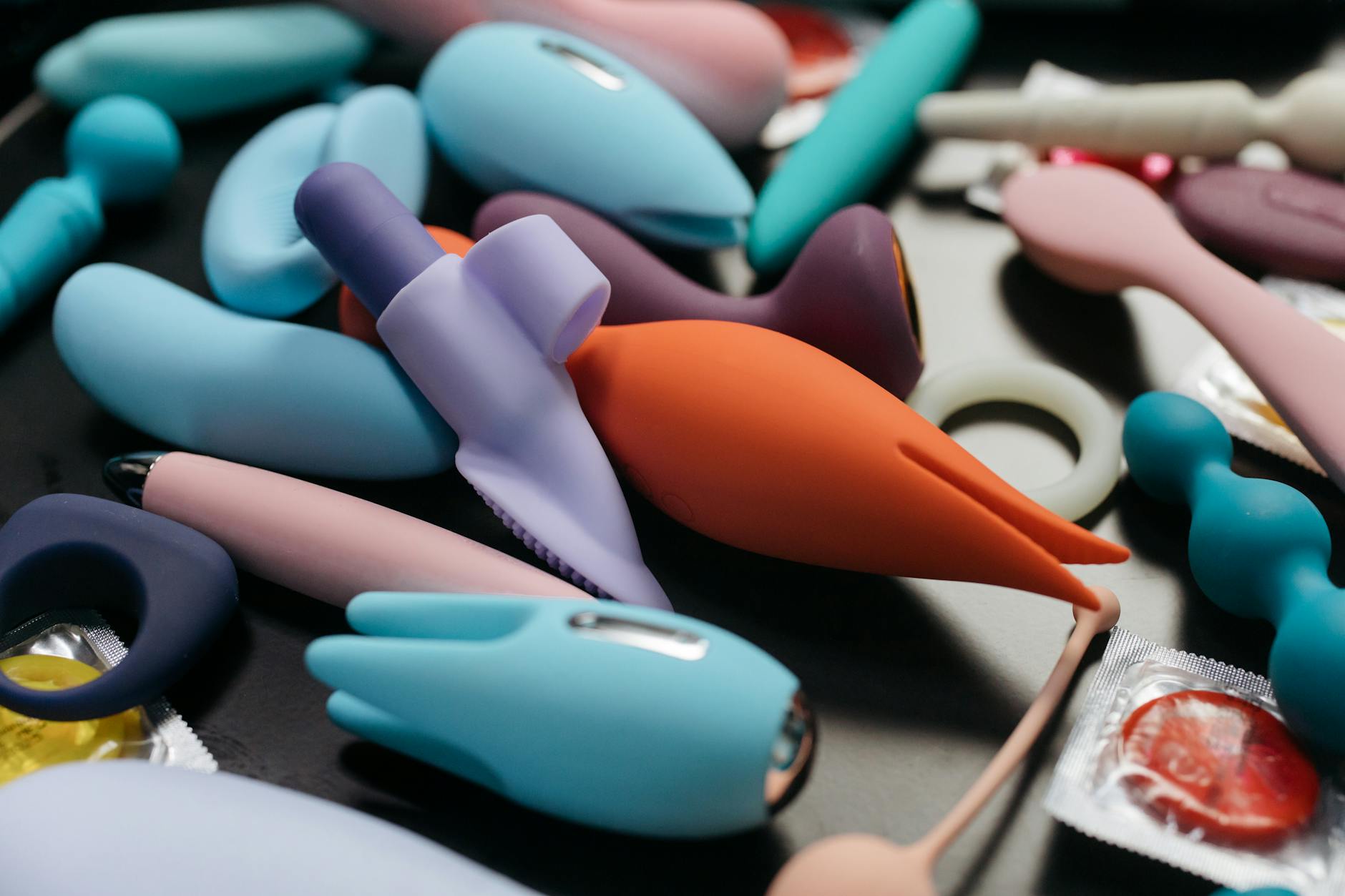 A sleek teal lemon clitoral vibrator on white silk fabric