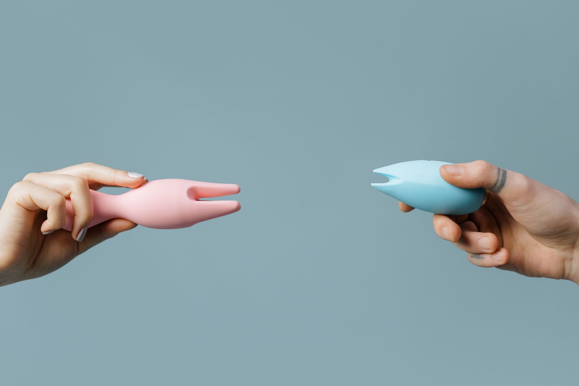 A hand holding an orange vibrator against a minimalistic purple backdrop, showcasing modern sensuality.